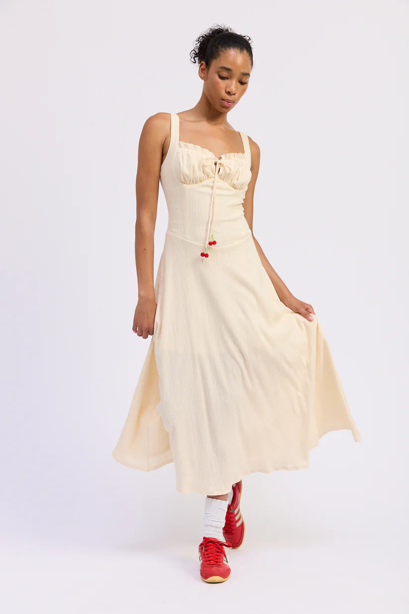 Cream sleeveless flowy midi dress on model