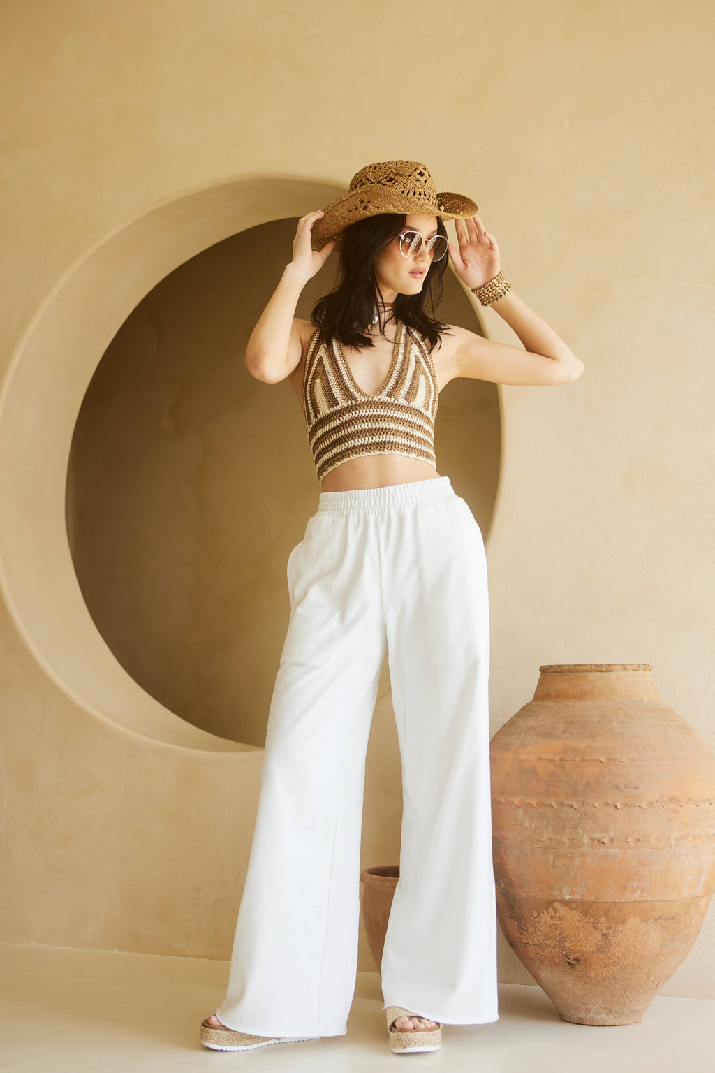 Woman wearing white wide leg pants and crop top
